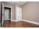 Neutral bedroom with wooden floors, white trim, built-in drawers and storage, and an open closet door at 115 Champion Dr, Carrollton, GA 30116