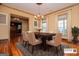 Formal dining room featuring hardwood floors, decorative rug, and abundant natural light from large windows at 115 Champion Dr, Carrollton, GA 30116