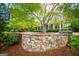 Landscaped front yard featuring a stone retaining wall and mature tree at 115 Champion Dr, Carrollton, GA 30116