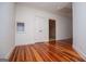 Hallway featuring hardwood floors, a window, and white walls at 115 Champion Dr, Carrollton, GA 30116