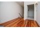 Hallway with hardwood floors leading to a doorway and staircase at 115 Champion Dr, Carrollton, GA 30116