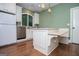 Kitchen area featuring white cabinets, stainless steel dishwasher, hardwood floors, and cozy island bench seating at 115 Champion Dr, Carrollton, GA 30116