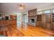 Open living room features a stone fireplace, hardwood floors, and views into the sunroom and kitchen area at 115 Champion Dr, Carrollton, GA 30116