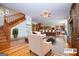 Open concept living room with hardwood floors, fireplace, staircase, and bar seating that leads to the kitchen at 115 Champion Dr, Carrollton, GA 30116