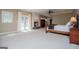 Expansive primary bedroom with fireplace, carpet, large windows, and sitting area at 115 Champion Dr, Carrollton, GA 30116
