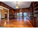 Office with custom built-in shelving, wood paneling and hardwood floors at 115 Champion Dr, Carrollton, GA 30116