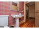 Stylish powder room featuring a pedestal sink and plaid wallpaper at 115 Champion Dr, Carrollton, GA 30116