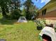 Large backyard with sparse lawn and a tent has some tools strewn about and a dog house at 1711 Mckenzie Dr, Decatur, GA 30032