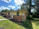 The side of this single story home shows wood siding and brick foundation with unkempt front lawn at 1711 Mckenzie Dr, Decatur, GA 30032