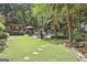 Expansive backyard with lush lawn, patio area, outdoor dining space, swimming pool, and mature trees, perfect for recreation at 100 Rosemont, Peachtree City, GA 30269