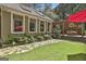Beautiful backyard patio with lush lawn, stone pathway, outdoor dining area, and mature trees, creating a serene outdoor space at 100 Rosemont, Peachtree City, GA 30269