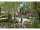 Lush backyard featuring a pool, patio, landscaped gardens, and mature trees at 100 Rosemont, Peachtree City, GA 30269