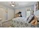 Bright bedroom with a patterned quilt, a ceiling fan, a window with blinds, and double closets at 100 Rosemont, Peachtree City, GA 30269