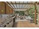 Outdoor deck with grill, dining area, and covered structure for shade, next to the swimming pool at 100 Rosemont, Peachtree City, GA 30269
