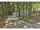 Long driveway leading to a charming home surrounded by lush greenery and mature trees at 100 Rosemont, Peachtree City, GA 30269