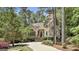Charming home exterior featuring a stone chimney, stucco facade, and lush landscaping at 100 Rosemont, Peachtree City, GA 30269