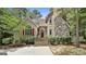 Inviting home exterior showcasing a stone chimney, stucco facade, and landscaped entrance at 100 Rosemont, Peachtree City, GA 30269