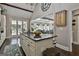 Kitchen island with granite countertop, cooktop, and seating, connecting to a living area and outdoor patio at 100 Rosemont, Peachtree City, GA 30269
