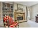 Cozy seating area in the main bedroom featuring a stone fireplace, built-in shelving, and a comfortable chair at 100 Rosemont, Peachtree City, GA 30269