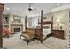 Bright and airy main bedroom with a four-poster bed, stone fireplace, and comfortable seating area at 100 Rosemont, Peachtree City, GA 30269
