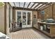 Outdoor kitchen with built-in grill, sink, and dining space, perfect for summer entertaining on the back deck at 100 Rosemont, Peachtree City, GA 30269