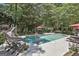 Gorgeous backyard pool with surrounding patio, waterslide, and lush greenery at 100 Rosemont, Peachtree City, GA 30269
