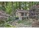 Charming shed set among lush greenery, a rock garden, and mature trees at 100 Rosemont, Peachtree City, GA 30269