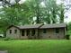 Charming brick home with a front porch, green lawn, and trees at 981 E Atlanta Rd, Stockbridge, GA 30281