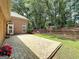 Brick patio, lawn, and fire pit with Adirondack chairs nestled in a wooded area at 211 English Oaks Ln, Mcdonough, GA 30253