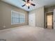 Bedroom features neutral carpet, ceiling fan, and a double door closet at 211 English Oaks Ln, Mcdonough, GA 30253