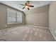 Bedroom featuring neutral carpet, ceiling fan, and a large window at 211 English Oaks Ln, Mcdonough, GA 30253