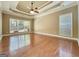 This spacious bedroom offers hardwood floors, a tray ceiling, and lots of natural light at 211 English Oaks Ln, Mcdonough, GA 30253