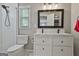 Bright bathroom with a dual sink vanity, gray walls, and tiled shower at 604 Magnolia Ln, Peachtree City, GA 30269