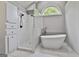 Bright bathroom features a soaking tub under an arched window and tiled shower with a glass partition at 604 Magnolia Ln, Peachtree City, GA 30269