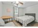 Bedroom features natural light, grey headboard bed, and a work desk at 604 Magnolia Ln, Peachtree City, GA 30269