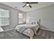 Neutral bedroom with a ceiling fan, carpet, two large windows, and a queen-size bed with neutral colors at 604 Magnolia Ln, Peachtree City, GA 30269