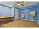 Bedroom featuring blue walls, modern lighting and a desk with stool at 604 Magnolia Ln, Peachtree City, GA 30269