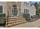 Elegant home entrance featuring stone steps, a decorative wreath, and stylish lighting fixtures at 604 Magnolia Ln, Peachtree City, GA 30269