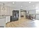 Open living space with wet bar, dining table, and living room area with wood flooring and neutral paint at 604 Magnolia Ln, Peachtree City, GA 30269