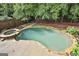 Backyard with in-ground pool, spa, stone trim and lush landscaping provides a private retreat at 604 Magnolia Ln, Peachtree City, GA 30269