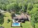 Aerial view of a beautiful home, pool, and large, green, and wooded property at 200 Camp Creek Trail, Peachtree City, GA 30269