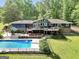 Large back yard with a private pool, covered patio, and manicured landscaping at 200 Camp Creek Trail, Peachtree City, GA 30269