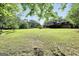 Expansive backyard featuring a large lawn and mature trees, perfect for outdoor activities and relaxation at 200 Camp Creek Trail, Peachtree City, GA 30269