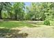 Expansive backyard featuring lush green grass and an open space in a wooded area at 200 Camp Creek Trail, Peachtree City, GA 30269