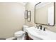 Stylish half-bath with vanity, decorative mirror, and modern fixtures at 200 Camp Creek Trail, Peachtree City, GA 30269