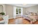 Light-filled bedroom featuring a vintage bed, hardwood floors, and a view of the lush outdoors at 200 Camp Creek Trail, Peachtree City, GA 30269