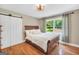 Comfortable bedroom features a wooden sleigh bed, white barn door, and views of the outdoor greenery at 200 Camp Creek Trail, Peachtree City, GA 30269