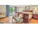 Elegant main bedroom featuring hardwood floors, a decorative bench, and access to a private balcony at 200 Camp Creek Trail, Peachtree City, GA 30269