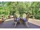 Cozy outdoor dining set on a wooden deck, perfect for enjoying meals with a picturesque wooded view at 200 Camp Creek Trail, Peachtree City, GA 30269