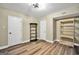 Room with two white doors, wood flooring, and shelving units at 200 Camp Creek Trail, Peachtree City, GA 30269